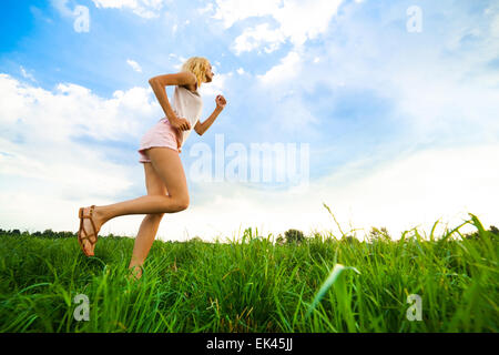 Junge Dame, die auf einer ländlichen Straße während des Sonnenuntergangs Stockfoto