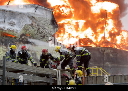 Gulei, Chinas Provinz Fujian. 7. April 2015. Feuerwehrleute versuchen, Feuer auf dem Gelände einer Chemiefabrik Explosion in Zhangzhou, Südost-China Fujian Provinz, 7. April 2015 zu löschen. Eine Xylol Anlage sickerte Öl und Feuer gefangen, was zu Explosionen und einem Brand drei nahe gelegenen Öllagertanks an Tenglong aromatischer Kohlenwasserstoffe (Zhangzhou) führte Co. Ltd. auf der Gulei Halbinsel in Zhangzhou City at 18:56 (1056GMT) am Montag. In der Anlage-Explosion wurden sechs Menschen verletzt. Bildnachweis: Jiang Kehong/Xinhua/Alamy Live-Nachrichten Stockfoto