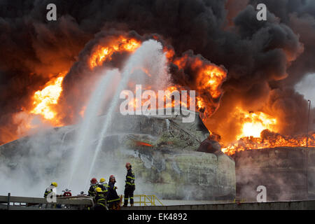 Gulei, Chinas Provinz Fujian. 7. April 2015. Feuerwehrleute versuchen, Feuer auf dem Gelände einer Chemiefabrik Explosion in Zhangzhou, Südost-China Fujian Provinz, 7. April 2015 zu löschen. Eine Xylol Anlage sickerte Öl und Feuer gefangen, was zu Explosionen und einem Brand drei nahe gelegenen Öllagertanks an Tenglong aromatischer Kohlenwasserstoffe (Zhangzhou) führte Co. Ltd. auf der Gulei Halbinsel in Zhangzhou City at 18:56 (1056GMT) am Montag. In der Anlage-Explosion wurden sechs Menschen verletzt. Bildnachweis: Jiang Kehong/Xinhua/Alamy Live-Nachrichten Stockfoto