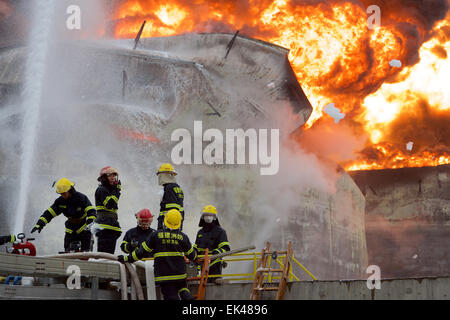 Gulei, Chinas Provinz Fujian. 7. April 2015. Feuerwehrleute versuchen, Feuer auf dem Gelände einer Chemiefabrik Explosion in Zhangzhou, Südost-China Fujian Provinz, 7. April 2015 zu löschen. Eine Xylol Anlage sickerte Öl und Feuer gefangen, was zu Explosionen und einem Brand drei nahe gelegenen Öllagertanks an Tenglong aromatischer Kohlenwasserstoffe (Zhangzhou) führte Co. Ltd. auf der Gulei Halbinsel in Zhangzhou City at 18:56 (1056GMT) am Montag. In der Anlage-Explosion wurden sechs Menschen verletzt. Bildnachweis: Jiang Kehong/Xinhua/Alamy Live-Nachrichten Stockfoto