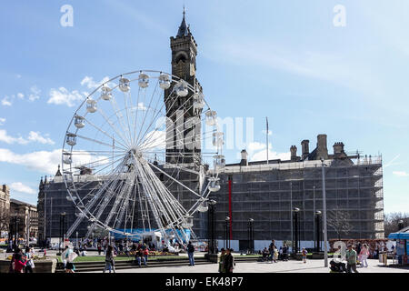 Bradford Eye, Big Wheel an einem sonnigen Tag. Massen und wartenden an Bord Fahrt mit dem Rathaus im Hintergrund Stockfoto