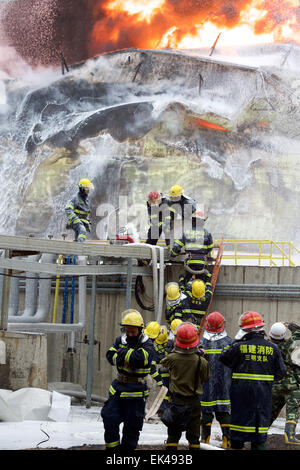 Gulei, Chinas Provinz Fujian. 7. April 2015. Feuerwehrleute versuchen, Feuer auf dem Gelände einer Chemiefabrik Explosion in Zhangzhou, Südost-China Fujian Provinz, 7. April 2015 zu löschen. Eine Xylol Anlage sickerte Öl und Feuer gefangen, was zu Explosionen und einem Brand drei nahe gelegenen Öllagertanks an Tenglong aromatischer Kohlenwasserstoffe (Zhangzhou) führte Co. Ltd. auf der Gulei Halbinsel in Zhangzhou City at 18:56 (1056GMT) am Montag. In der Anlage-Explosion wurden sechs Menschen verletzt. Bildnachweis: Jiang Kehong/Xinhua/Alamy Live-Nachrichten Stockfoto