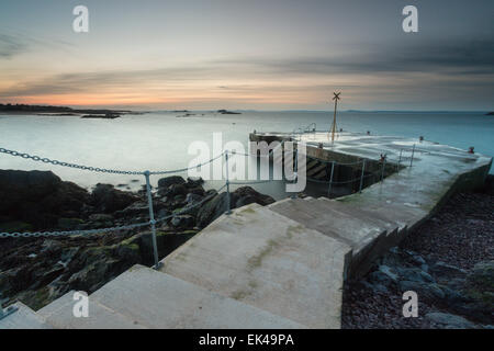 Das letzte Licht des Tages verschwindet über den Himmel an der alten Pier in North Berwick. Stockfoto