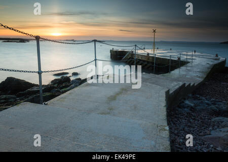 Eine Sonne-Säule erreicht in den Himmel, als das letzte Licht des Tages über den Himmel an der alten Pier in North Berwick verschwindet. In der Stockfoto