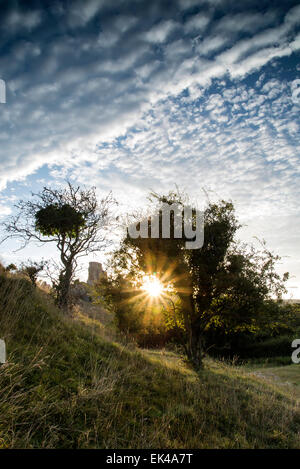 Burgruine Landschaft bei Sonnenaufgang mit Sunburst hinter Schloss Stockfoto