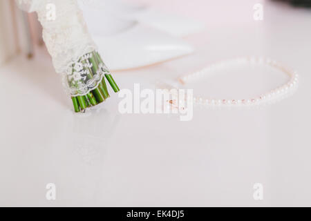 Hochzeit Perlen Ohrringe und Halskette hautnah mit Hochzeitsschuhe und Strauß-Hintergrund Stockfoto