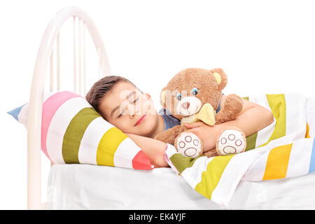 Süße kleine Kind schlafen mit einem Teddybär bedeckt mit einer Decke im Bett isoliert auf weißem Hintergrund Stockfoto