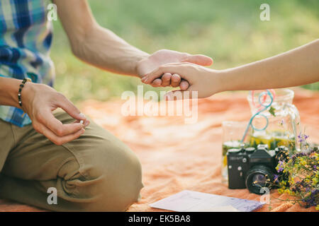 Verlobungsring Vorschlag Hände hautnah im Picknick Stockfoto