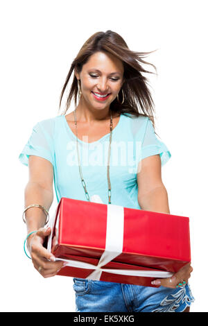 Nahaufnahme Portrait Happy Young Woman Casual Kleidung hält Red großen Geschenk-Box mit White Ribbon während in die Kamera schaut. Isolated on White Background. Stockfoto