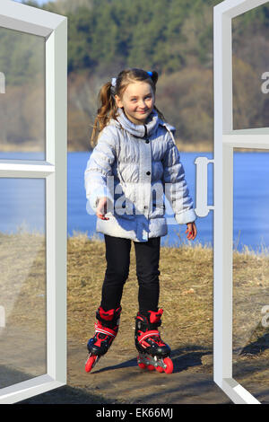 Mädchen geht in Inline Skates auf dem Boden gesehen aus dem Hause Fenster Stockfoto