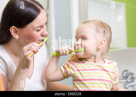 süße Mutter lehrt Kinder Zähne putzen Stockfoto