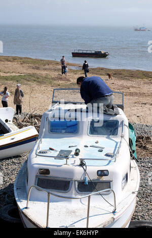 Mann, die hoch oben auf kleines Boot, die Durchführung von Wartungsarbeiten Stockfoto