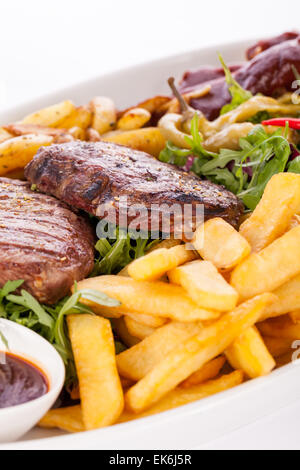 Gesunde Platte mit gemischtem Fleisch einschließlich gegrilltes Steak, knusprig Panierter Hühner- und Rindfleisch auf einem Bett aus frischen grünen grünen gemischten sa Stockfoto