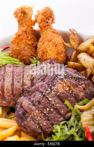 Gesunde Platte mit gemischtem Fleisch einschließlich gegrilltes Steak, knusprig Panierter Hühner- und Rindfleisch auf einem Bett aus frischen grünen grünen gemischten sa Stockfoto