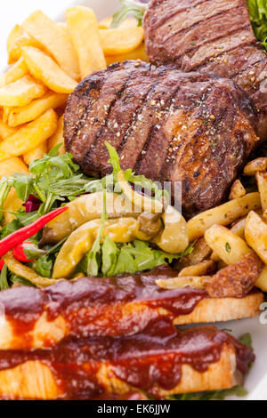 Gesunde Platte mit gemischtem Fleisch einschließlich gegrilltes Steak, knusprig Panierter Hühner- und Rindfleisch auf einem Bett aus frischen grünen grünen gemischten sa Stockfoto