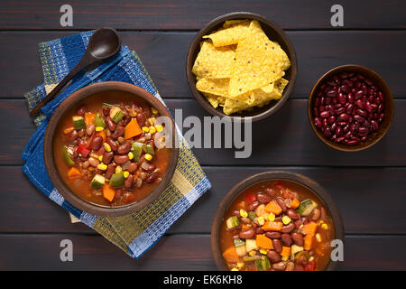 Overhead Schuss vegetarische Chili Gericht mit Kidney-Bohnen, Karotten, Zucchini, Paprika, Mais, Tomaten Stockfoto