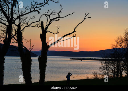 Lough Swilly, County Donegal, Irland. 7. April 2015. Irland Wetter: Eine Frau wacht die untergehende Sonne über Lough Swilly markiert das Ende von einem warmen und sonnigen Frühlingstag in Donegal.  Bildnachweis: George Sweeney/Alamy Live-Nachrichten Stockfoto