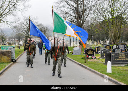 Männer, gekleidet in Irischen paramilitärischen Uniformen, deren Gesichter vom Militärischen scrim Schals erfassten Irische Flaggen in Milltown Friedhof, während der Hauptversammlung Stockfoto