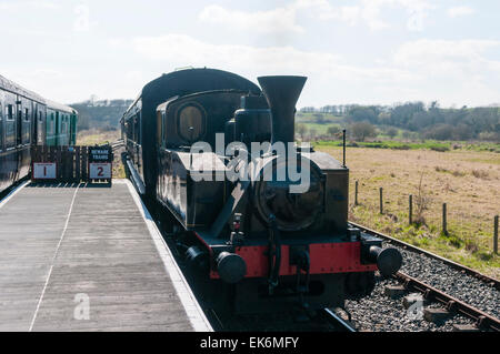 Dampfzug nähert sich eine Plattform mit einem anderen Zug stationär. Stockfoto