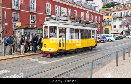 LISSABON PORTUGAL GELBE ALTE STRAßENBAHN UND PASSAGIERE IM ZENTRUM VON LISSABON Stockfoto