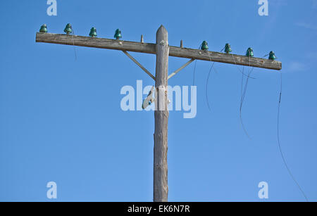 Eine alte elektrische Holzpfahl und Stromleitungen auf einen blauen Himmelshintergrund Stockfoto