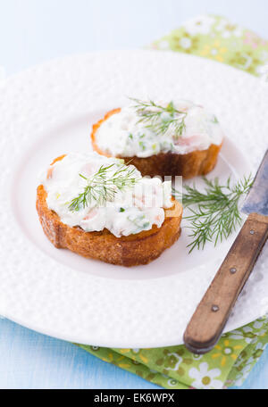 Kanapees mit Weichkäse zu verbreiten, auf weißen Teller, selektiven Fokus Stockfoto