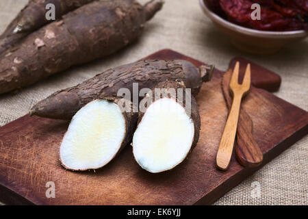 Schneiden Sie Maniok Hälften (lat. Manihot Esculenta) auf Holzbrett fotografiert mit natürlichem Licht (Tiefenschärfe) Stockfoto