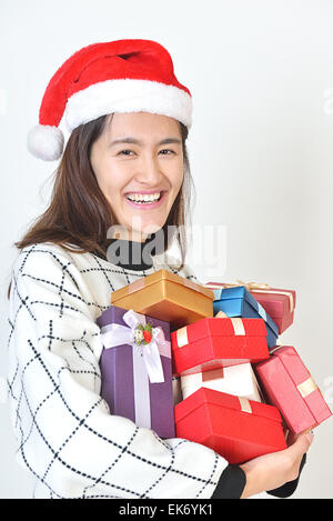 Asiatische Frau mit einem Arm voller Geschenke nach Weihnachtseinkaufen zu gehen. isoliert auf weißem Hintergrund Stockfoto