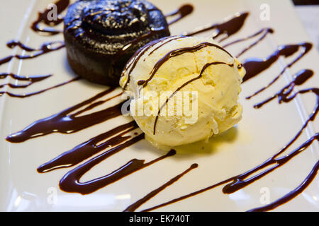 Eine Kugel Vanille-Eis mit Schokoladensauce in einer Platte Stockfoto