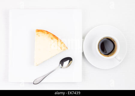 Frühstück Essen Hintergrund. Tasse Kaffee mit Stück Käsekuchen auf Platte. Tasse Espresso mit Dessert auf weißen Tisch Stockfoto