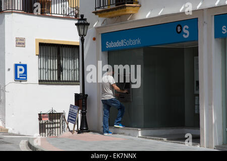 Mann mit einem ATM bei Banco Sabadell Bank in Andalusien Spanien Stockfoto