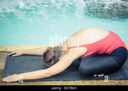 Frau Yoga zu praktizieren in der Nähe von Wasserfall. Kind-Pose. Balasana Stockfoto