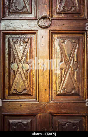 Nahaufnahme eines alten dekoriert und geschnitzte Holztür mit rostigen Eisen Klopfer. Vignettierung hinzugefügt, dramatischen Effekt. Stockfoto