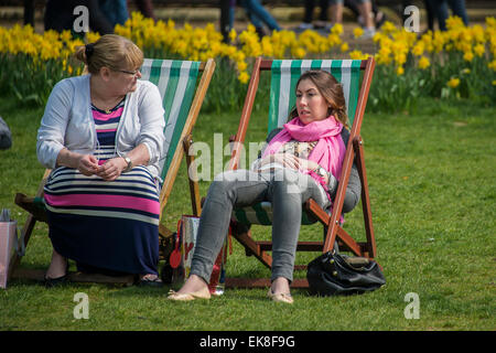 London, UK. 8. April 2015. Die Frühlingssonne bringt Arbeitnehmer und Touristen um die Mittagszeit. Sie genießen in den Liegestühlen entspannen oder auch die Verwendung als Outdoor-Büros. Green Park, London, 8. April 2015. Bildnachweis: Guy Bell/Alamy Live-Nachrichten Stockfoto