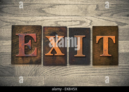 Das Wort "EXIT" Thema in Vintage, Tinte befleckt, hölzerne Buchdruck Typ auf gemasertem Holz Hintergrund geschrieben. Stockfoto