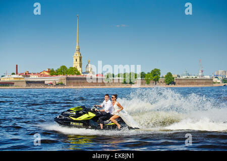 Brautpaar gehen auf Jet-Skis, die Braut und Bräutigam auf dem Hintergrund der Peter und Paul Fortress, die Wasserfläche des Flusses Newa Stockfoto