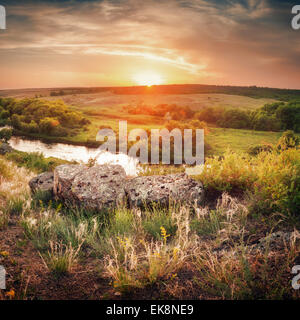 Schönen Sommer Sonnenuntergang am Fluss mit blauer Himmel, Wolken, grasgrün, Steinen und Wasser mit Reflexion in der Ukraine Stockfoto