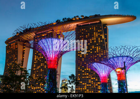 Gärten durch die Bucht und die Marina Bay Sands Hotel in der Abenddämmerung. Singapur, Asien. Stockfoto