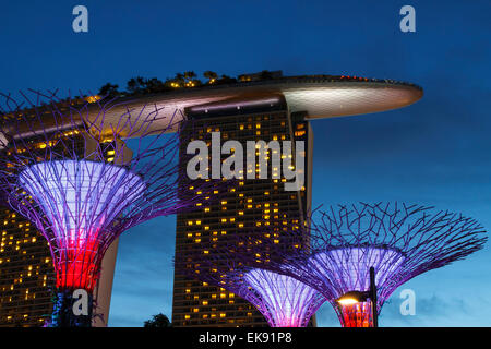 Gärten durch die Bucht und die Marina Bay Sands Hotel in der Abenddämmerung. Singapur, Asien. Stockfoto