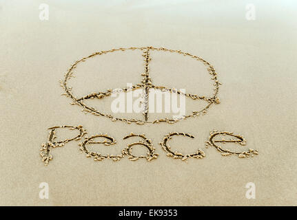 Peace-Zeichen in den Strandsand gezeichnet. Stockfoto