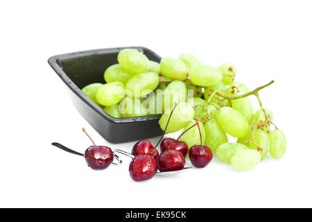 Kirschen mit Wassertropfen in einem Löffel und eine Schale mit Trauben-iso Stockfoto