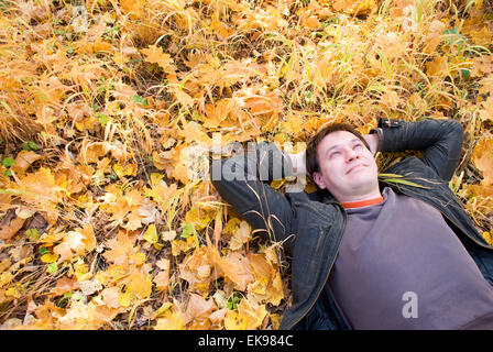 Porträt eines Mannes auf Herbstlaub liegend Stockfoto