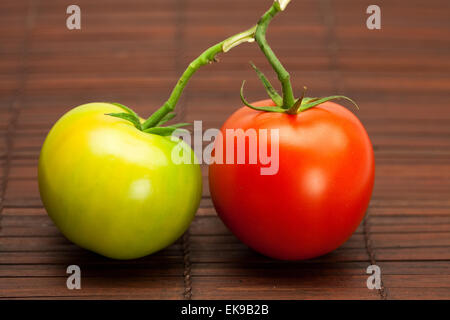 rote und grüne Tomaten auf einer Bambusmatte Stockfoto