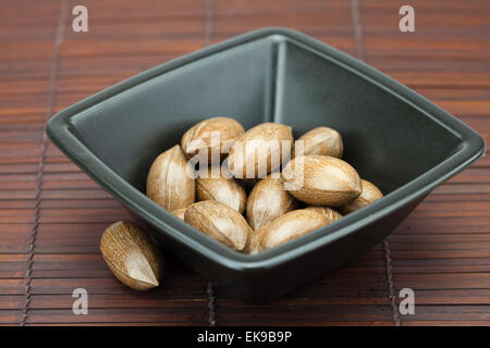 Pekannüsse in einer Schüssel auf einer Bambusmatte Stockfoto