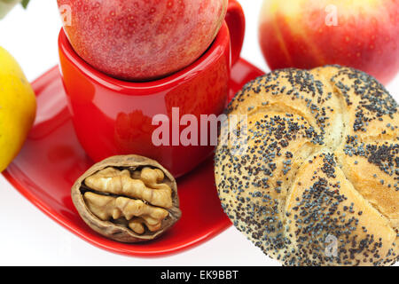 Laib mit Mohn, Quitten, Äpfel und Walnüsse in einer Tasse und s Stockfoto