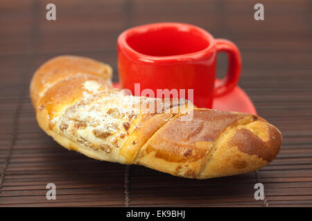 Tasse mit einer Platte und Rollen auf einer Bambusmatte Stockfoto