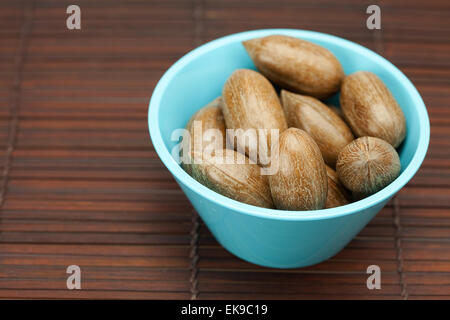 Pekannüsse in einer Schüssel auf einer Bambusmatte Stockfoto