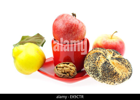 Laib mit Mohn, Quitten, Äpfel und Walnüsse in einer Tasse und s Stockfoto