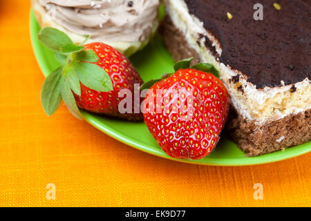 Kuchen und Erdbeeren auf die orangen Stoff liegen Stockfoto