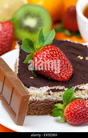 Tee mit Zitrone, Schokolade, Kiwi, Kuchen und Erdbeeren auf der Ora liegend Stockfoto